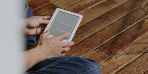 A child enjoying a book on an E-Ink reader in a comfortable home environment.