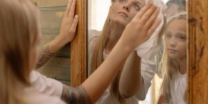 A parent and child looking into a mirror, representing emotional reflection and regulation.