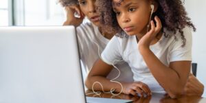 A parent and child exploring technology together on a laptop