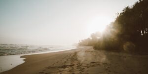 A serene, empty beach at sunrise representing a calm travel destination.