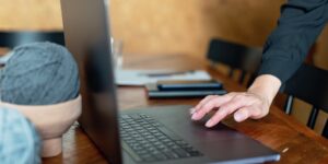 A person closing their laptop at home to signify the end of the workday.
