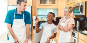 Parent and child cooking together in a bright, modern kitchen.