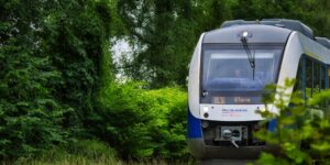 A scenic view of a regional train traveling through a green valley.