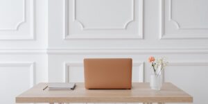 A clean, modern home office desk setup with a laptop and coffee.