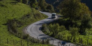 A scenic view of a regional bus on a countryside road.