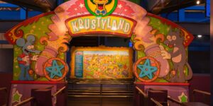 A peaceful, empty theme park entrance at sunrise representing the off-peak travel strategy.