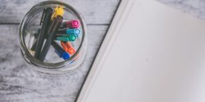 A glass jar filled with colorful slips of paper on a desk, representing an emotional vocabulary tool.
