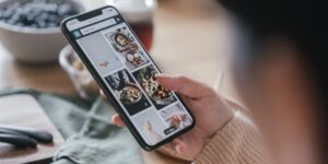 A smartphone showing a meal planning app on a kitchen counter with fresh produce.