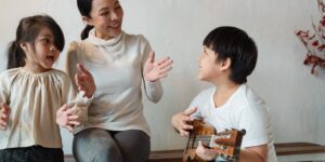 Two siblings and a parent practicing calm communication in a living room.