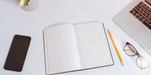 A clean, inviting desk setup with a journal, representing the start of a reflective journaling practice.