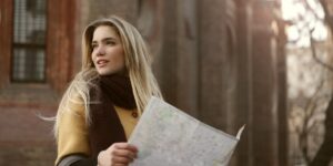 A person exploring a historic neighborhood street with a map in hand.