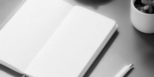 A clean, modern workspace featuring an open journal and pen, representing clarity and self-reflection.