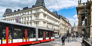 A modern city intersection showing integrated public transport systems like bikes, trains, and walking paths.