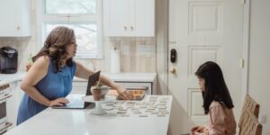 Parent and child engaged in a math game at a kitchen table.