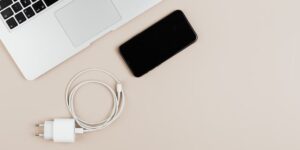 A clean, organized flat-lay of travel essentials and a digital planner on a wooden surface.