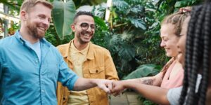 A diverse group of parents collaborating in a community garden to support each other with childcare.