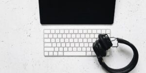 A clean desk setup featuring a tablet and headphones, representing second-hand tech for kids.