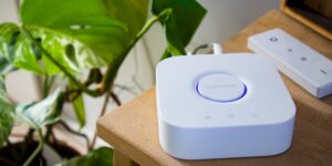A minimalist smart home hub device on a living room table.