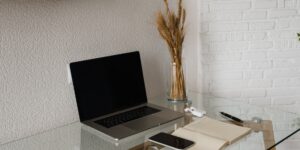 A minimalist home office setup with a laptop and notebook, symbolizing financial planning.