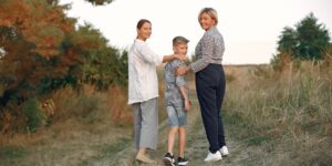 A multi-generational family walking together on a sunny coastal path.