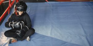 A child athlete focusing on preparation before a sports practice.
