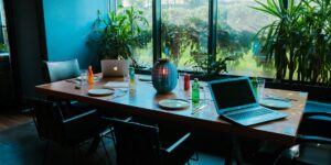 A laptop and passport on a desk with a view, representing remote work travel.