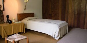 A calm, minimalist bedroom designed for sensory regulation with warm, soft lighting.