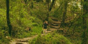A family hiking together in a lush forest to illustrate a weekend immersion trip.
