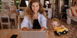 A digital nomad parent working in a bright home office setting.