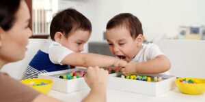 A parent observing children playing peacefully in a bright, modern living room.