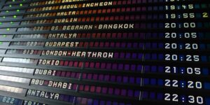 A modern airport departure board with morning light.