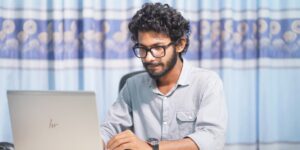 A professional digital nomad working in a modern home office with a city view.