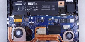 A modular laptop with visible internal components on a clean desk.