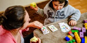 Parent and child engaging in an emotional vocabulary game at the kitchen table.