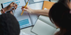 Diverse parents planning a collaborative childcare schedule in a modern home.