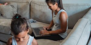 A professional parent managing work-life balance in a home office.