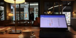 A clean, productive workspace in a quiet cafe setting with a laptop and coffee.