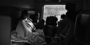 A family enjoying a comfortable train ride with organized luggage in a modern carriage.