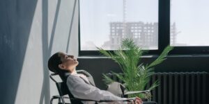 A person taking a quiet, mindful break in a sunlit home office.