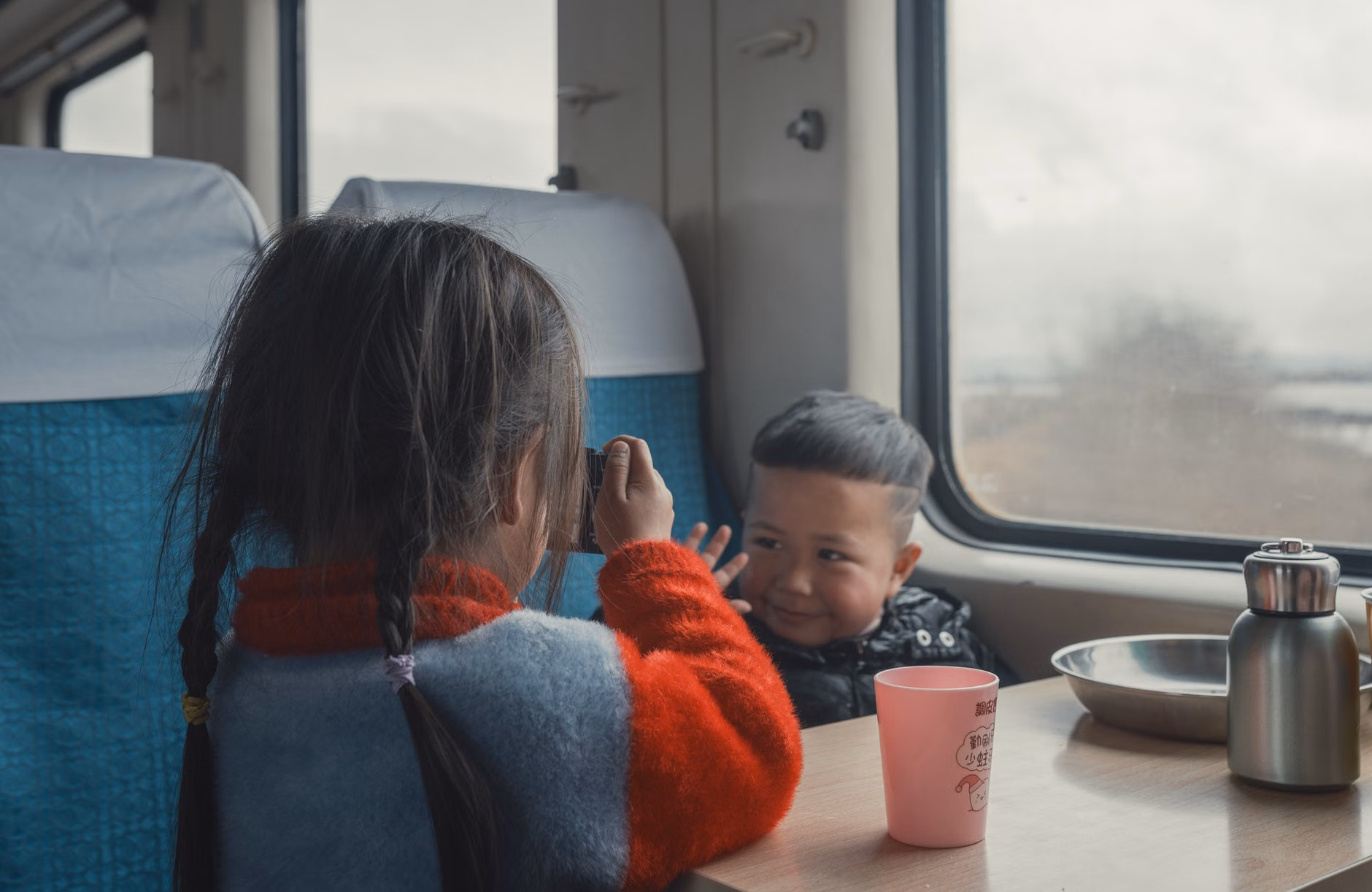 Family playing games on a train journey along the coast.