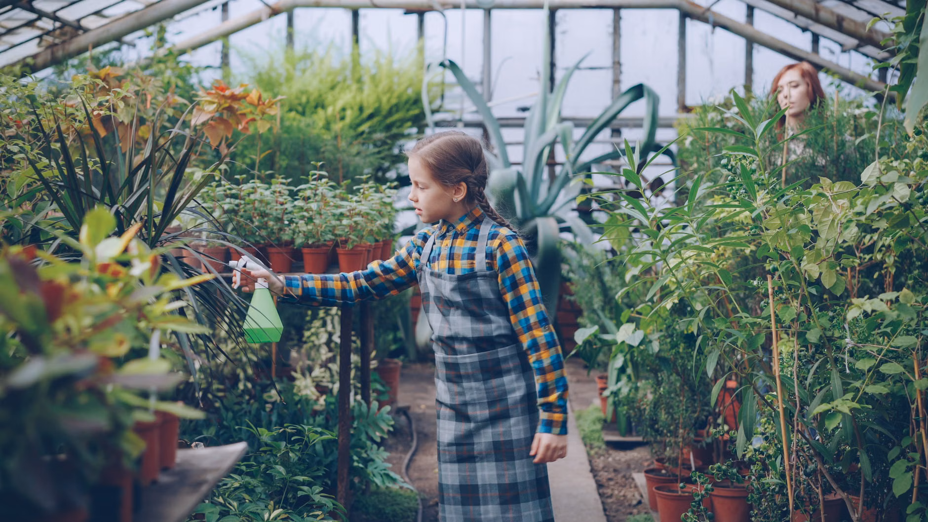 Child planting herbs in a vertical balcony garden