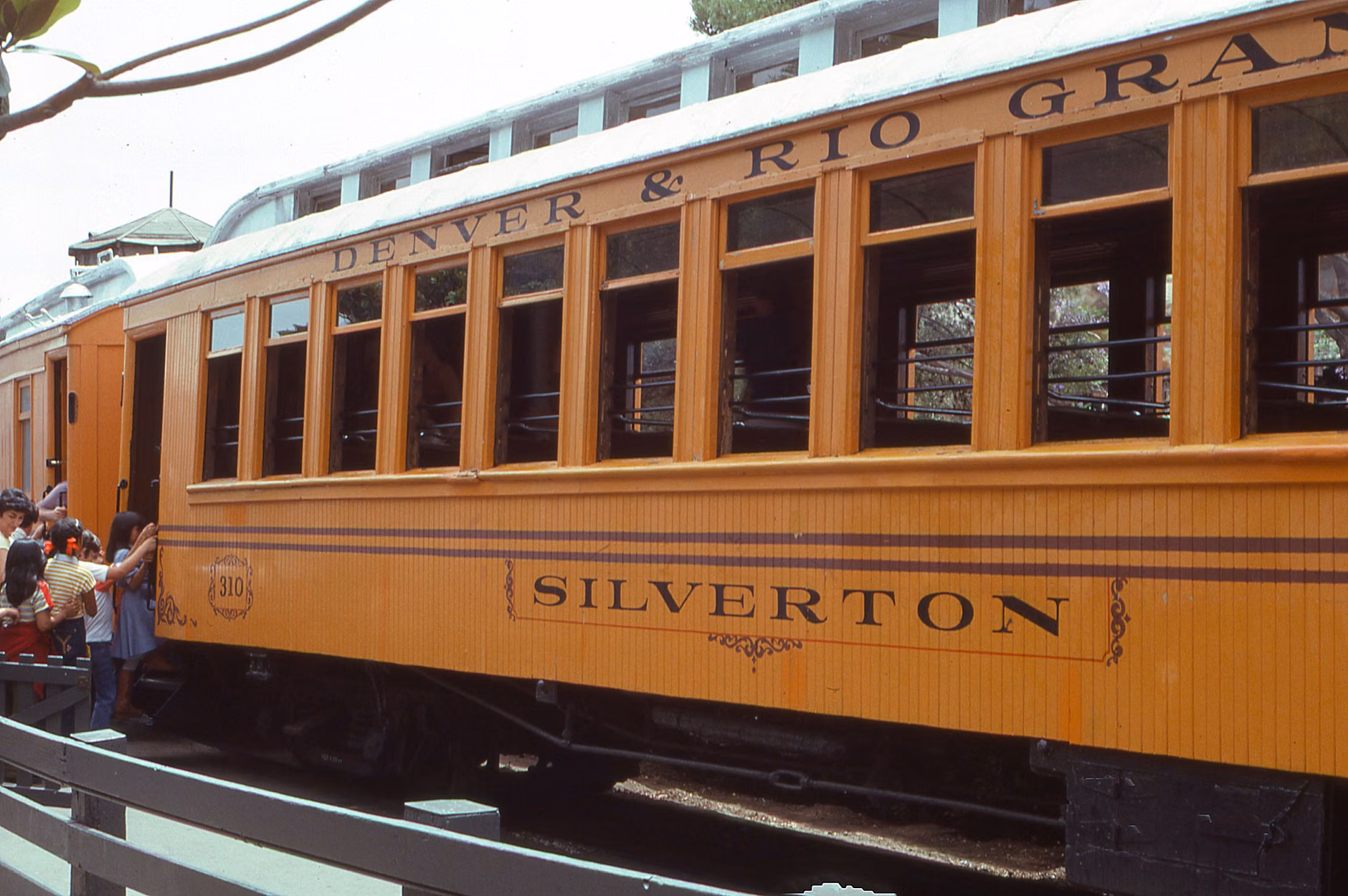 A family enjoying the view from a vintage train carriage.
