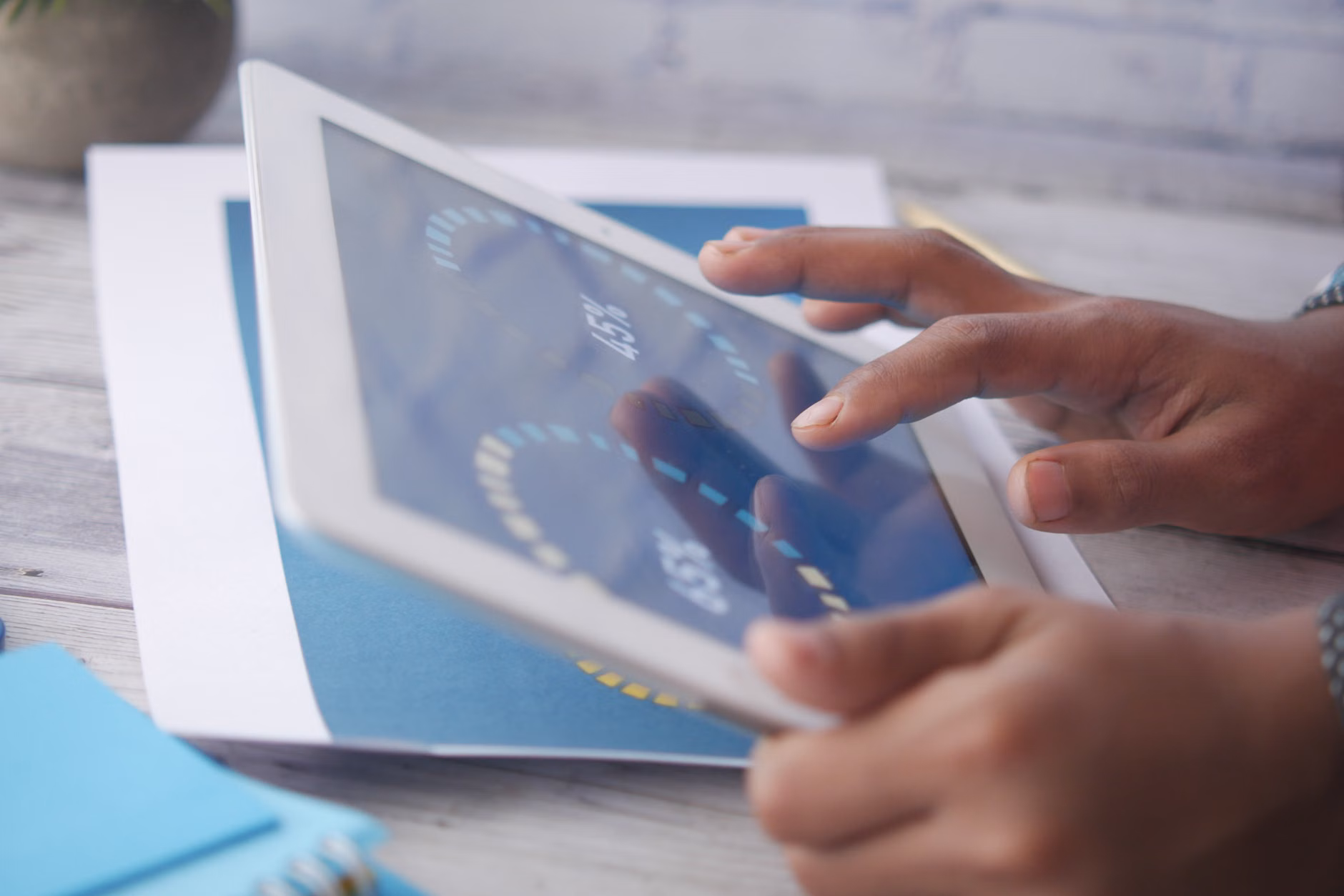 Child's hands holding a tablet with an educational interface.
