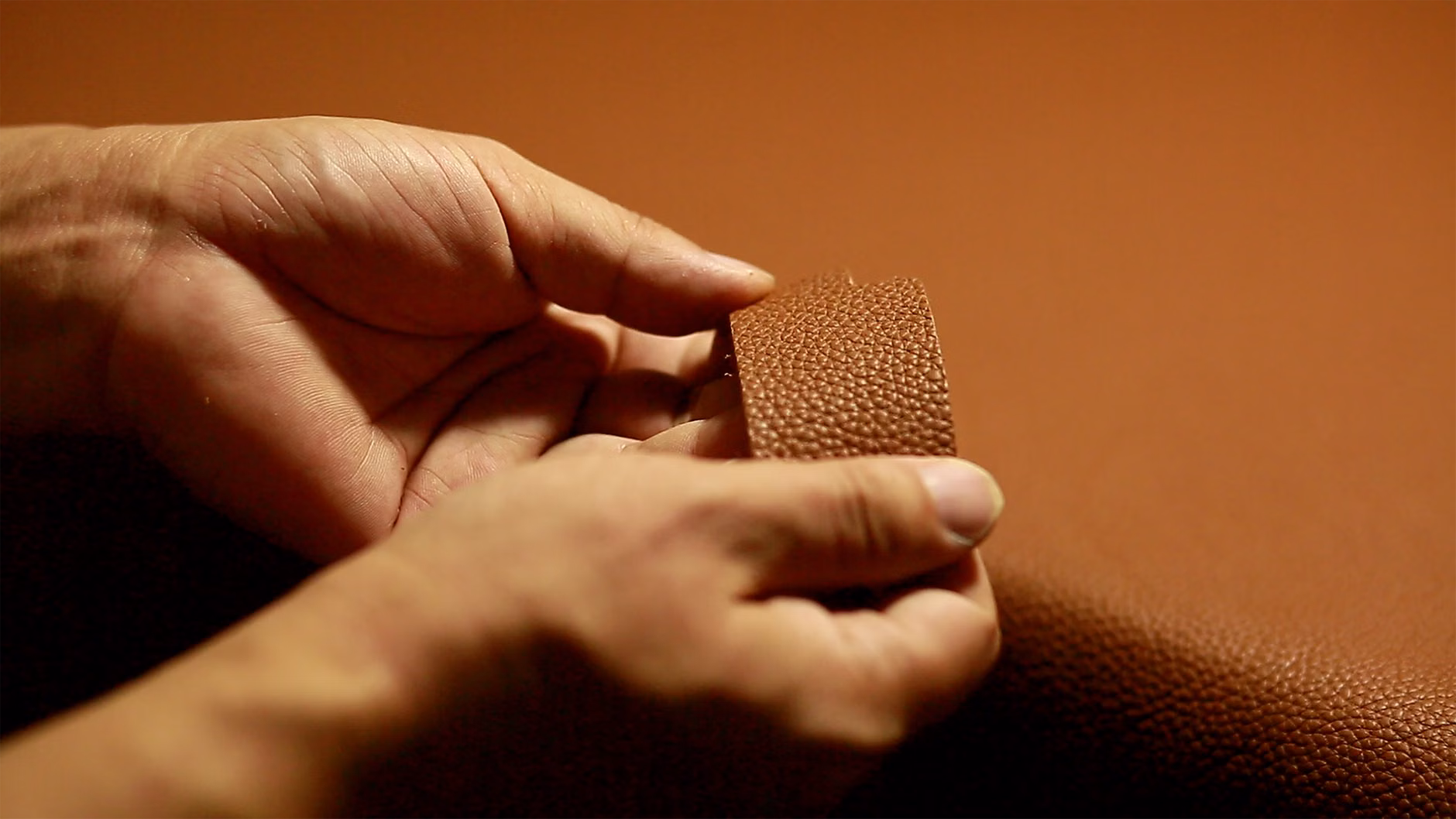 Close-up of a person authenticating a luxury leather product.