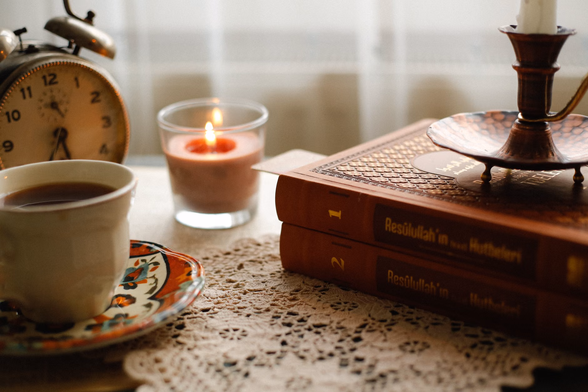 A quiet morning scene with tea and a book overlooking mountain peaks.