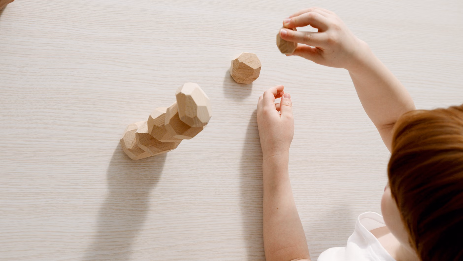 Toddler engaging in tactile sensory play with a smooth stone.
