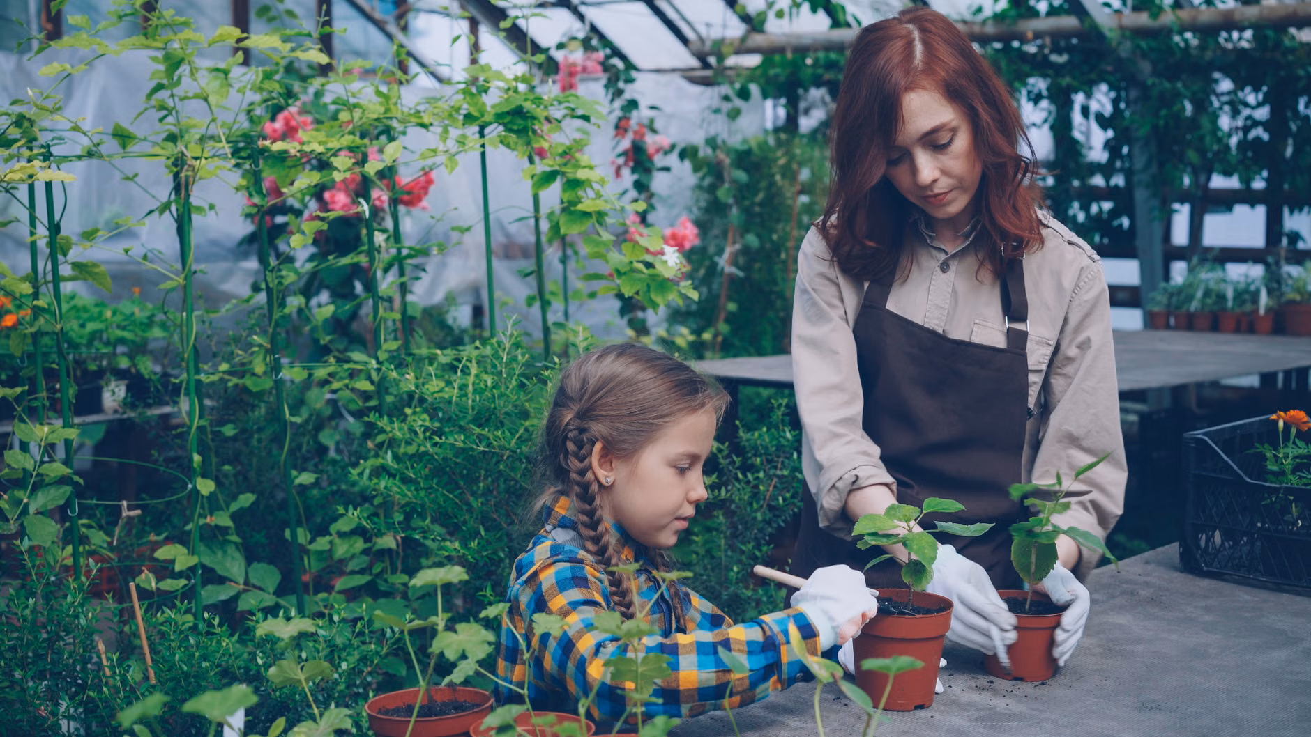 A parent and child gardening on a small urban balcony.