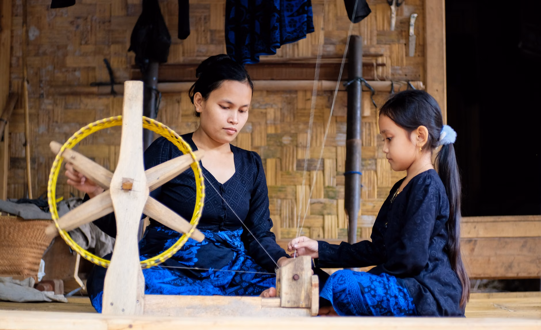 A child learning a traditional craft from a local artisan during a cultural immersion trip.