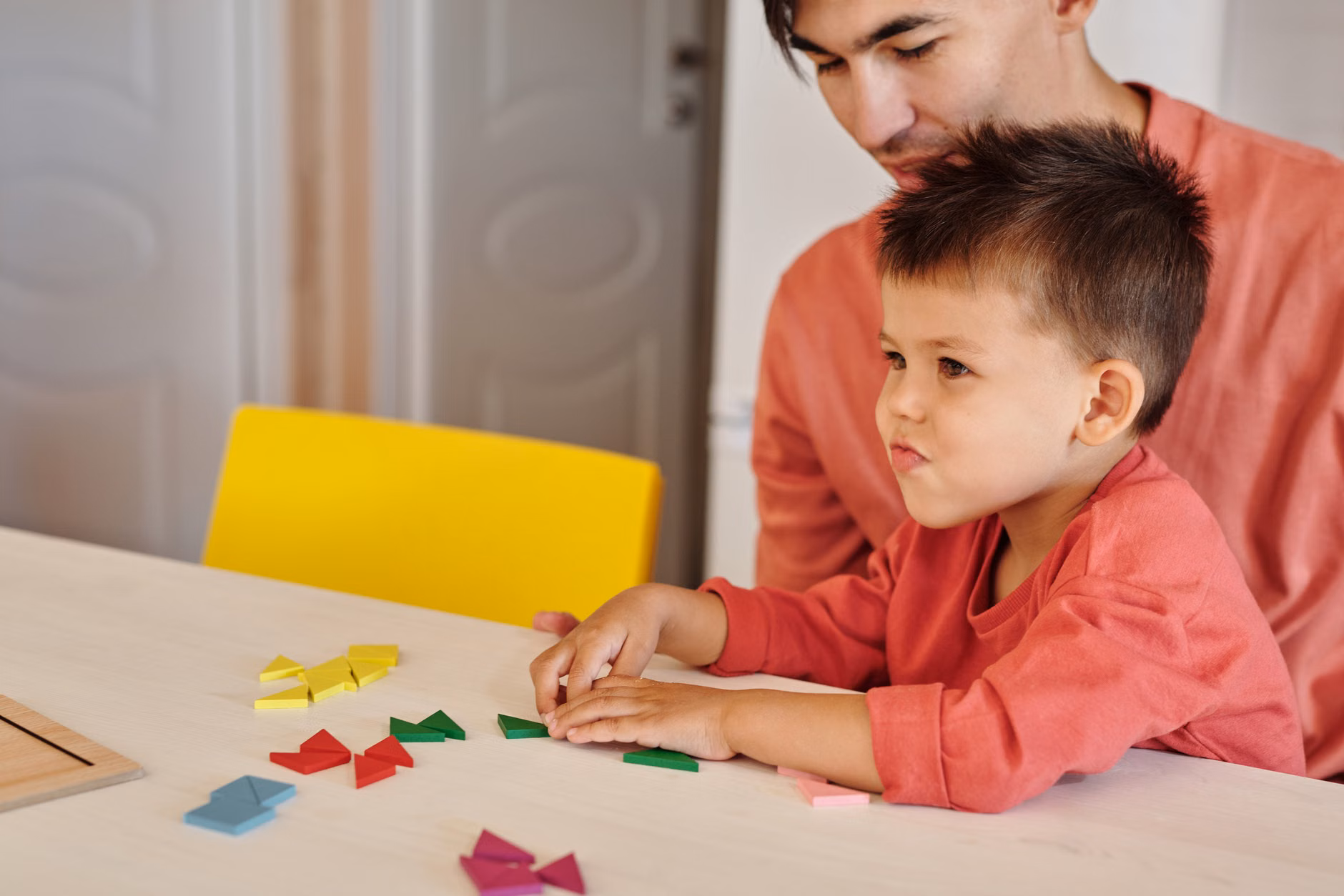 Parent and toddler working together on a puzzle, emphasizing supportive guidance.