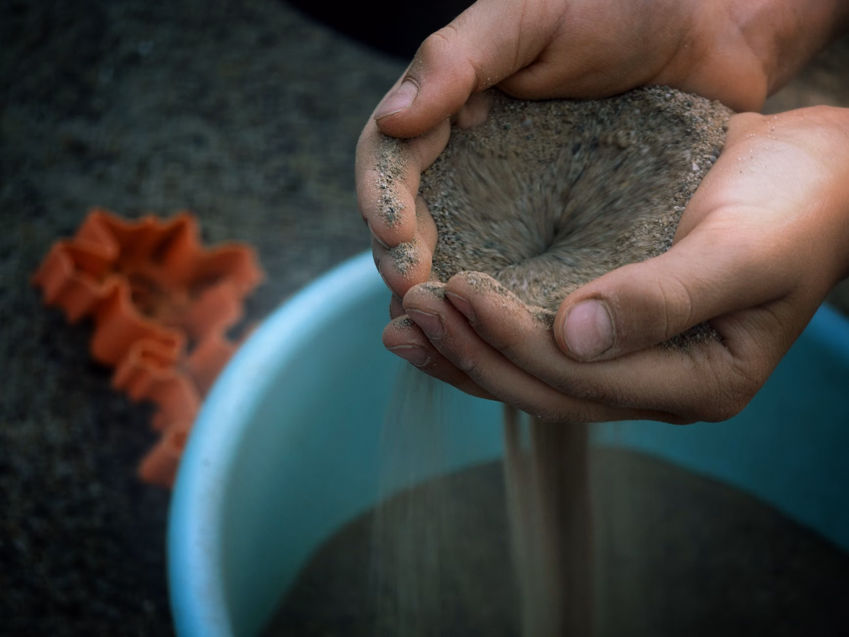 A tactile sensory bin with kinetic sand and tools for grounding.